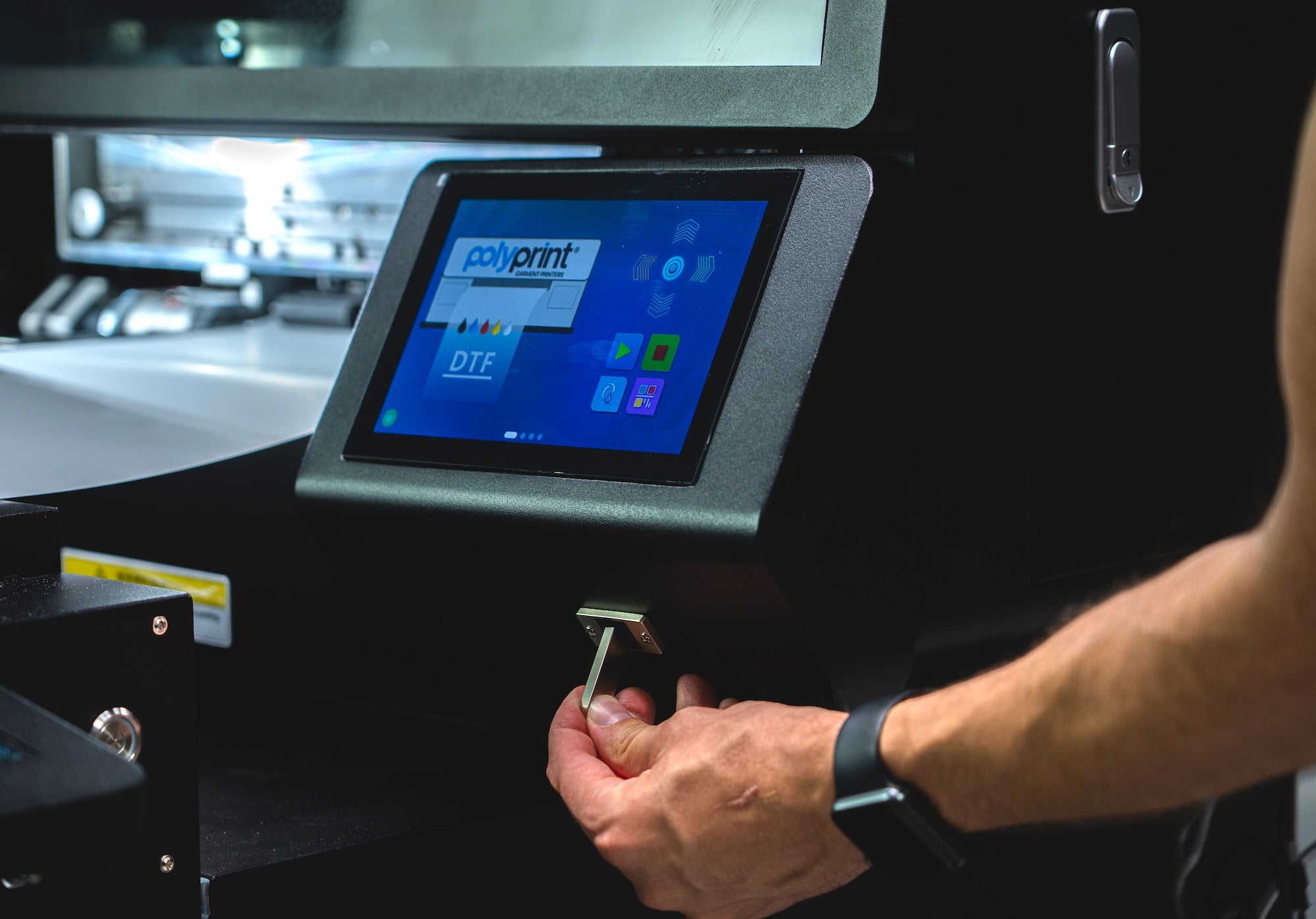 Person using Filmjet Mini DTF printer with a Polyprint touchscreen interface