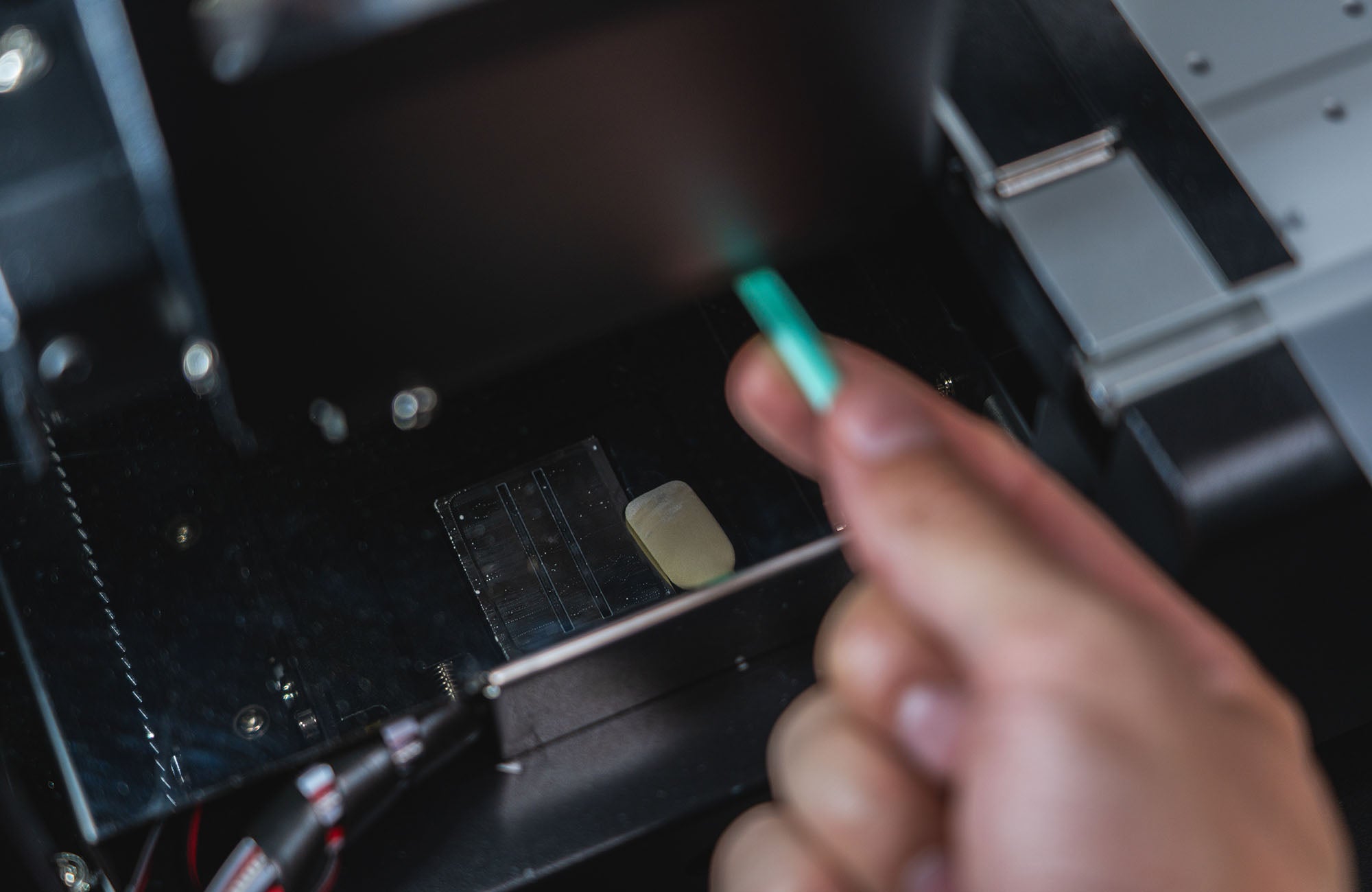 Person performing print head cleaning using a swab on Filmjet Mini DTF printer